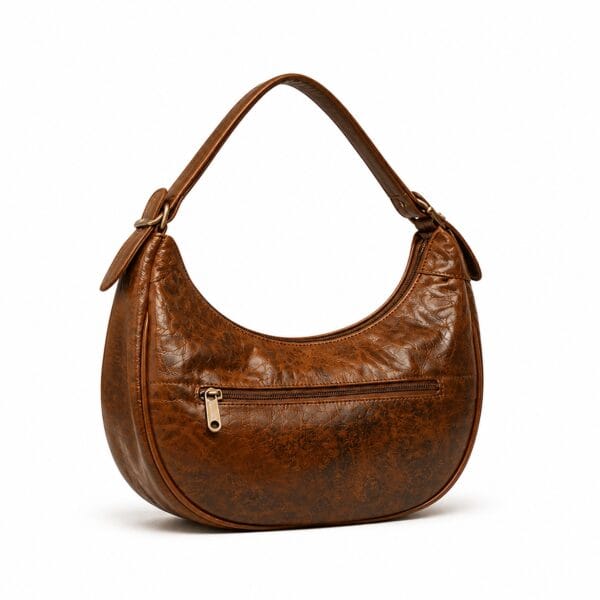 Half-moon crescent hobo bag in distressed caramel-brown leather with a top zip, a front zip pocket and a gold-tone buckle on the strap.