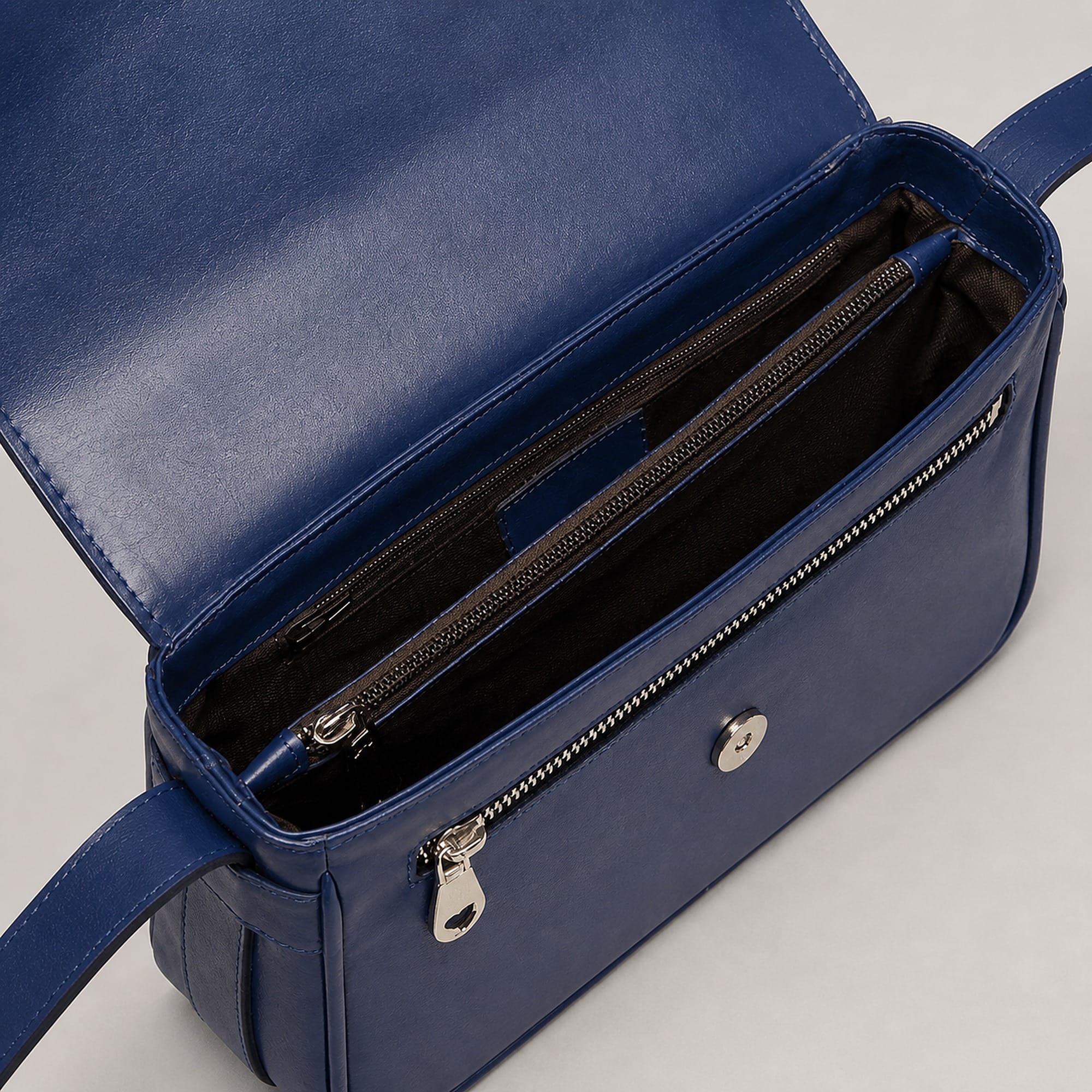 Under the flap: a lined main compartment with an interior zip pocket.
